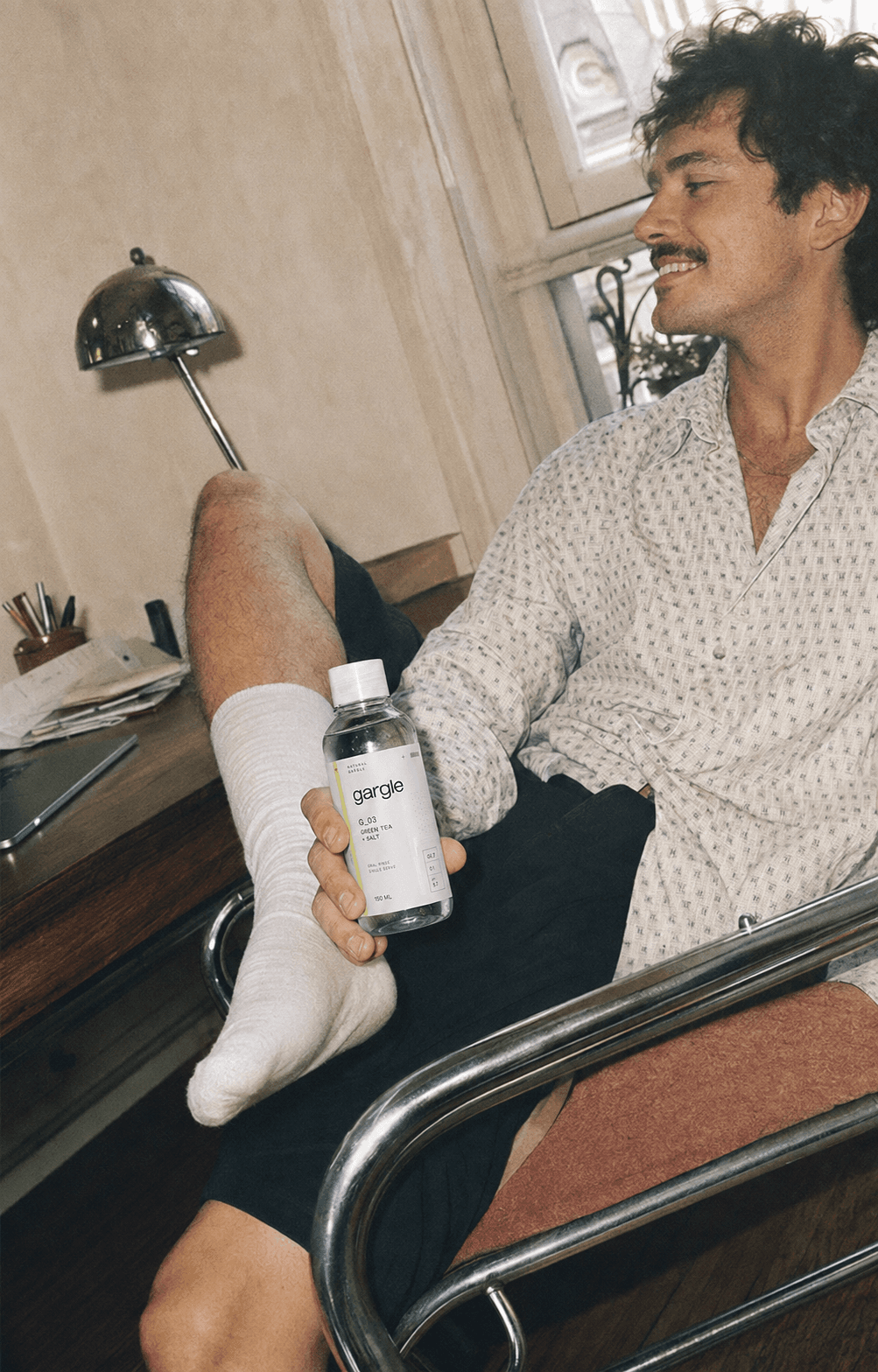 A man at home holding the Gargle bottle.