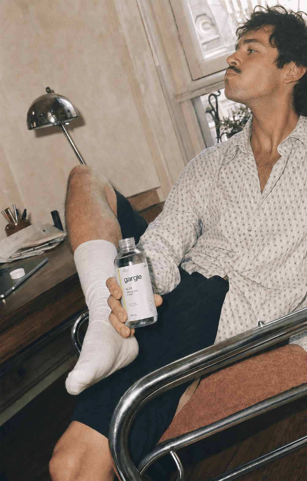 A man relaxing at home, holding the Gargle bottle.