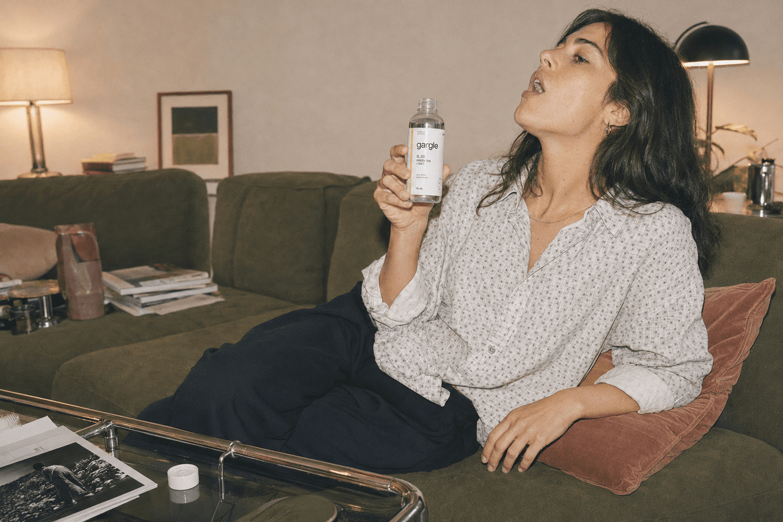 A woman relaxing on a sofa, gargling in the evening.